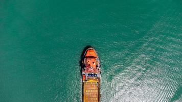 vista aerea sulla parte superiore della nave da carico che trasporta container e corre per il porto di scalo merci di esportazione verso l'oceano personalizzato internazionale. concetto di trasporto tecnologico, sdoganamento, banner webinar. foto