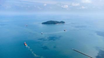 vista aerea dal drone del golfo della tailandia che mostra la nave da carico con lo sfondo dell'isola dei topi e dell'isola dei gatti, songkhla, sud della tailandia foto