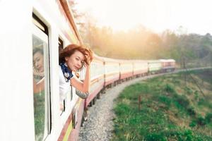 donna guarda fuori dalla finestra viaggiando in treno foto