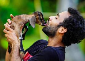 ragazzo con un simpatico animale domestico di capra foto