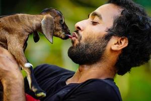 ragazzo con un simpatico animale domestico di capra foto