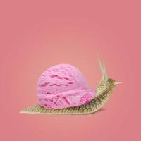 la lumaca porta il gelato su uno sfondo rosa. concetto estivo. idea creativa. foto