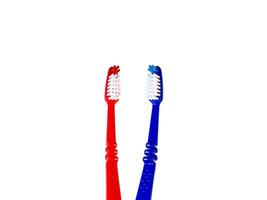 due spazzolini da denti su sfondo bianco. spazzolini da denti blu e rossi foto