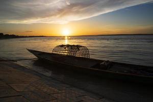 una barca di legno sul mare contro il cielo durante il tramonto foto