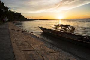 una barca di legno sul mare contro il cielo durante il tramonto foto