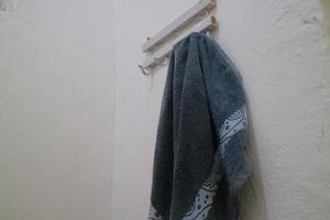 asciugamano bagnato blu scuro appeso alla parete del bagno foto