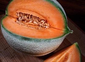 tagliare il melone maturo su una tavola di legno. foto