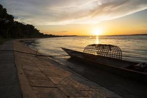 una barca di legno sul mare contro il cielo durante il tramonto foto