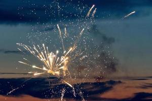 fuochi d'artificio che esplodono al tramonto foto