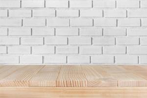 piano del tavolo in legno su sfondo di mattoni bianchi: può essere utilizzato per il montaggio o visualizzare i tuoi prodotti foto