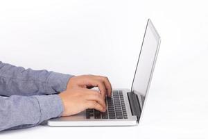 mani che digitano sulla tastiera del computer portatile su sfondo bianco foto