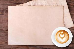 carta bianca con la matita e una tazza di caffè su legno foto