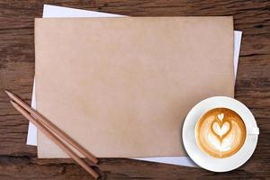 carta bianca con la matita e una tazza di caffè su legno foto