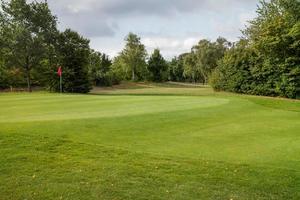 campo da golf con erba e nuvole nel cielo foto