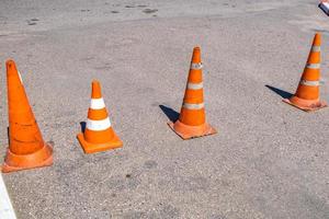 cono di pericolo di traffico arancione bianco sulla riparazione della strada asfaltata foto