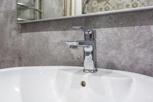 lavandino del rubinetto dell'acqua in acciaio con rubinetto nel bagno soppalcato costoso foto
