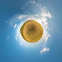 trasformazione del piccolo pianeta del panorama sferico a 360 gradi. vista aerea astratta sferica in campo in una bella serata con bellissime nuvole fantastiche. curvatura dello spazio. foto