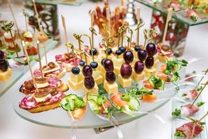 ristorazione. cibo fuori sede. tavolo da buffet con varie tartine, panini, hamburger e snack. foto