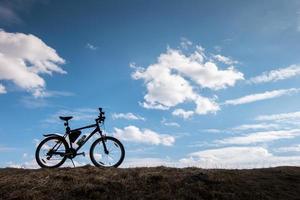 silhouette di bici nel cielo blu con nuvole. simbolo di indipendenza e libertà foto