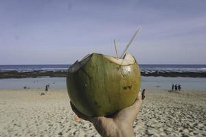 foto di succo di cocco fresco su una spiaggia tropicale