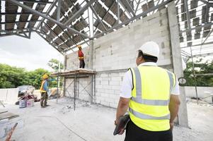 ingegneri e architetti supervisionano la costruzione di case nei cantieri residenziali. foto