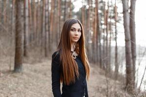 bella giovane donna in una camicia nera su uno sfondo di foresta. foto