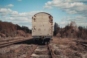 le vecchie carrozze sporche del treno stanno sui binari della ferrovia foto