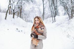 giovane donna graziosa in abiti invernali alla moda su uno sfondo di parco foto