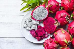 frutta fresca del drago viola bianca e rosa rossa tropicale nel concetto di frutta sana della tailandia asiatica, fetta di frutta del drago e metà tagliata su piatto bianco con fondo pitahaya foto