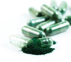 capsula verde della medicina di erbe isolata su fondo bianco foto