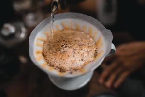 il primo piano delle mani il barista fa il caffè foto