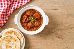 pollo tikka masala cibo piccante a base di carne al curry con roti o pane naan foto