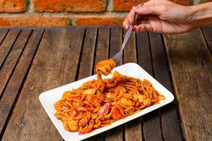 spaghetti sul piatto bianco e sullo sfondo di legno. foto