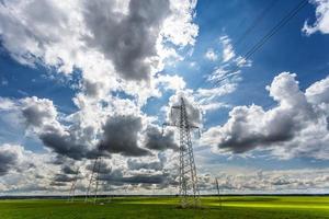 silhouette delle torri del pilone elettrico ad alta tensione sullo sfondo di bellissime nuvole foto