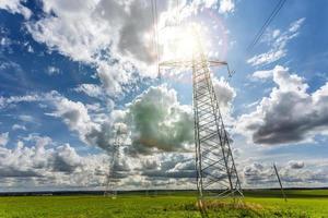 silhouette delle torri del pilone elettrico ad alta tensione sullo sfondo di bellissime nuvole foto