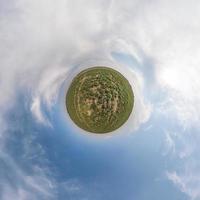 trasformazione del piccolo pianeta verde del panorama sferico a 360 gradi. vista aerea astratta sferica in campo con bellissime nuvole fantastiche. curvatura dello spazio. foto