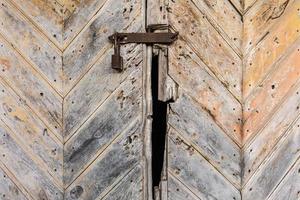 vecchio lucchetto arrugginito sulla porta di legno foto