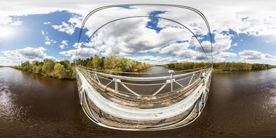 panorama sferico completo senza giunte dell'antenna 360 gradi di angolo vista dal ponte di legno sospeso pedonale sopra l'ampio fiume in una giornata di sole in proiezione equirettangolare. skybox per contenuti vr ar foto