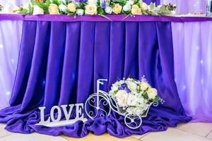 rappresentano fiori a forma di bicicletta e un'iscrizione amore vicino al tavolo festivo foto