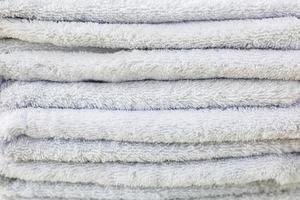 pila di asciugamani da bagno in peluche bianco pastello. foto