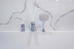 rubinetto e miscelatore doccia nella cabina doccia ad angolo con attacco doccia a parete foto