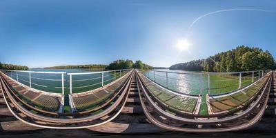 panorama sferico completo senza soluzione di continuità vista angolare a 360 gradi su struttura in acciaio costruzione di un enorme ponte ferroviario ferroviario sul lago. Panorama a 360 gradi in proiezione equidistante equirettangolare, contenuto vr ar foto