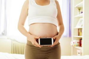 donna incinta con il cellulare foto