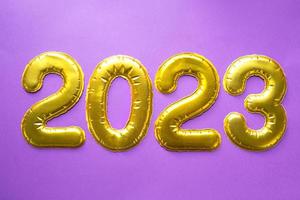 felice anno nuovo- numeri d'oro 2023 su sfondo viola con paillettes, stelle, glitter, luci di ghirlande. saluti, cartolina. calendario, copertina. foto