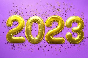 felice anno nuovo- numeri d'oro 2023 su sfondo viola con paillettes, stelle, glitter, luci di ghirlande. saluti, cartolina. calendario, copertina. foto