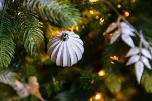 albero di capodanno decorato classico di natale. albero di natale con decorazioni bianche e argento, ornamenti giocattolo e palla. appartamento di design d'interni in stile classico moderno. la vigilia di natale a casa. foto