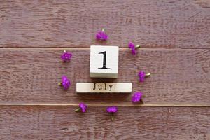 primo giorno di luglio, sfondo colorato con calendario e fiori rosa foto
