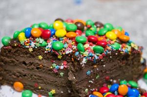 torta al cioccolato con decorazioni colorate foto