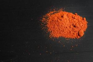 polvere di paprika su sfondo nero foto