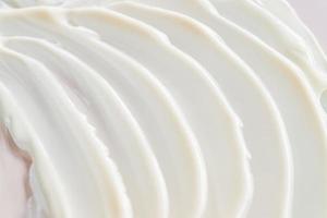 consistenza della lozione. sfondo bianco crema cosmetica sbavato. crema per il viso da vicino foto